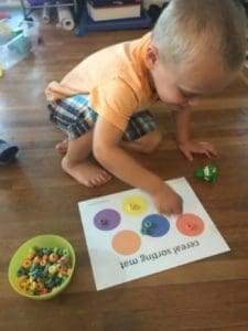 child sorting colored cereal