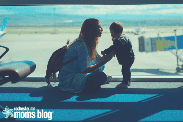 mom kneeling by toddler in airport