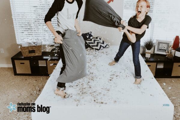 kids having pillow fight on bed