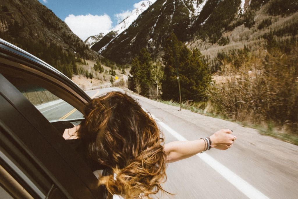 girl with head and arm out the window