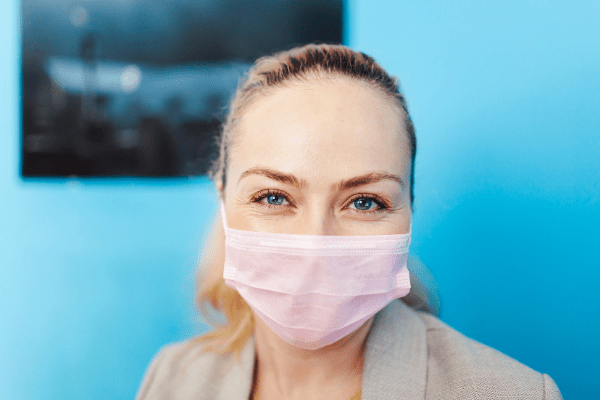 woman smiling under mask