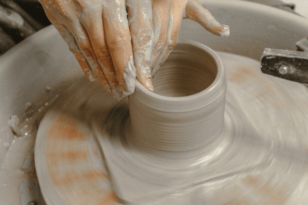 Hands with clay on a pottery wheel