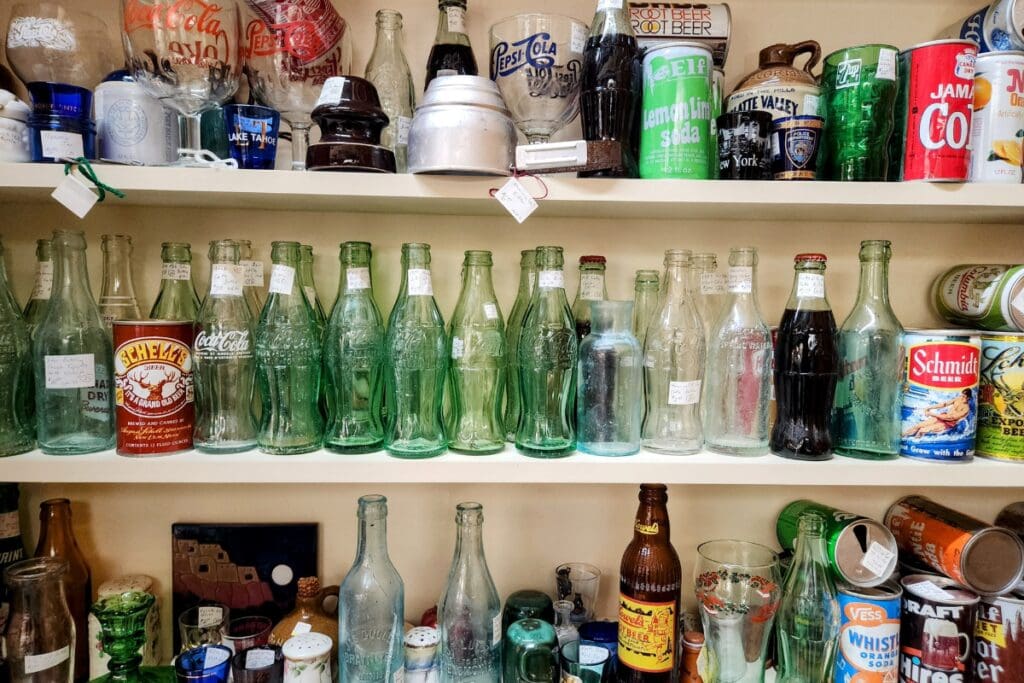 Old bottles, cans and glassware on shelves at Country Side Antique Mall in Cannon Falls, MN